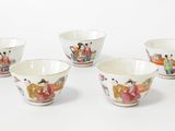 four small bowls with asian designs on them sitting on a white surface