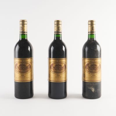 trois bouteilles de vin posées les unes à côté des autres sur une surface blanche