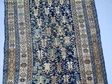 un tapis oriental bleu et or posé sur une surface blanche