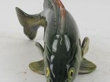 a green fish figurine that is sitting on a table
