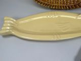 a yellow plate with a fish on it next to a wicker basket