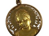 Gros plan sur une médaille d'or portant le visage d'une femme