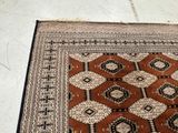 a rug on the floor with a cat sitting on top of it