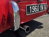 une voiture rouge garée sur le bord de la route