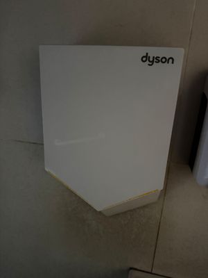 a toilet paper dispenser in the corner of a bathroom