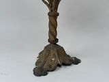 an antique brass candelab with flowers and leaves on a stand