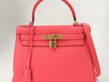 un sac Hermès rose avec un fermoir doré sur la poignée