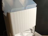 a white trash can sitting on top of a wooden table