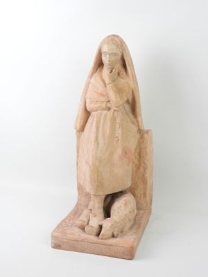 statue of a woman sitting on a rock with her hands on her knees