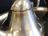 a silver tea pot that is sitting in a sink
