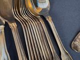 a lot of silver spoons and spoon spoons on the table