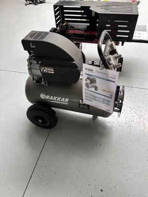a small air compressor sitting on a cart in a warehouse