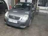 a silver car parked in a garage next to a black car