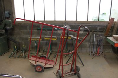 un diable rouge avec une poignée rouge dans un garage