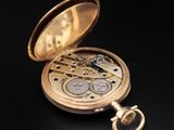a gold pocket watch sitting on a black surface