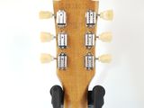 the headstock of an acoustic guitar on a white background