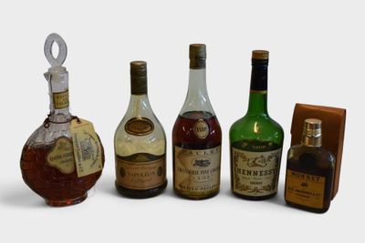 several bottles of liquor are lined up in a row on a white surface