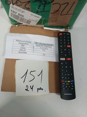 une télécommande posée à côté d'un carton sur lequel est accrochée une étiquette de prix