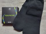 a close up of a pair of black socks next to a box of aquagym