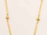 a necklace with green stones and gold beads on a white background