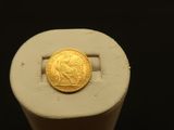 une pièce d'or posée sur un objet blanc