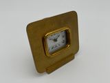 a gold clock sitting on top of a white table