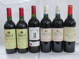 several bottles of wine are lined up on a white surface