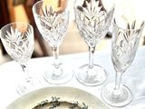 quatre verres à vin et une assiette posés sur une table
