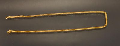a pair of gold chains on a black surface