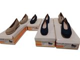 Plusieurs paires de chaussures sont alignées sur des boîtes posées sur une surface blanche