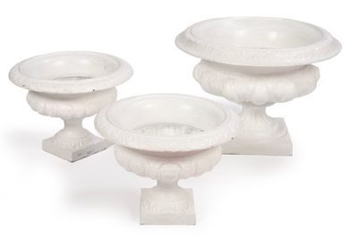 trois vases blancs posés les uns à côté des autres sur une surface blanche