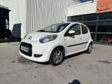 la petite voiture blanche est garée devant un bâtiment
