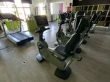 une salle de sport équipée d'une rangée de vélos d'appartement et de tapis de course