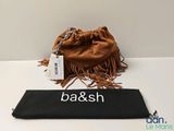 un sac en papier brun sur lequel est inscrit un nom, posé sur une table