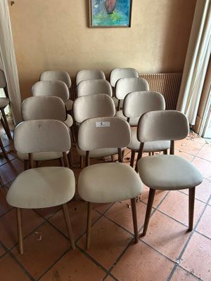 a lot of chairs in a room with a painting on the wall