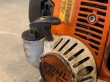 an orange and black chainsaw sitting on top of a cement floor