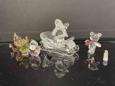 plusieurs figurines en verre représentant des souris et un traîneau, posées sur une table