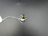 Gros plan sur une bague ornée d'une pierre verte