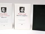 three books on a white table with a black cover and a white background