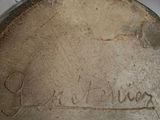 a brown vase with writing on it sitting on a table
