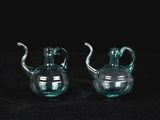une paire de théières en verre vert sur fond noir