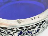 a blue glass bowl with a silver rim on a table