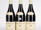 trois bouteilles de vin rouge posées l'une à côté de l'autre sur une surface blanche