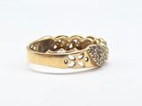a close up of a gold ring with a diamond center