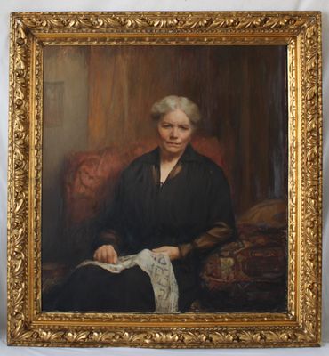 portrait d'une femme en robe noire, assise sur une chaise rouge