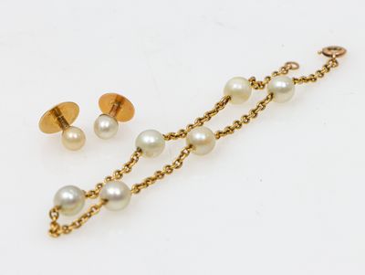 un gros plan sur une paire de boucles d'oreilles en perles et en or