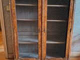 une armoire en bois avec une porte vitrée, posée au sol