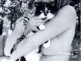 photographie en noir et blanc d'une femme en bikini tenant un chat dans ses bras