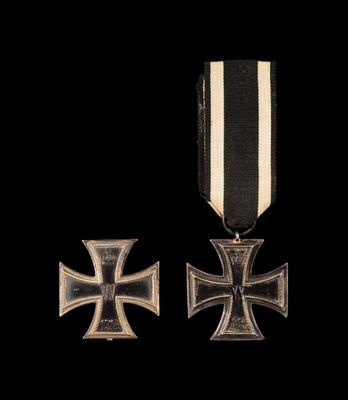 un gros plan d'une médaille et d'une croix sur fond noir