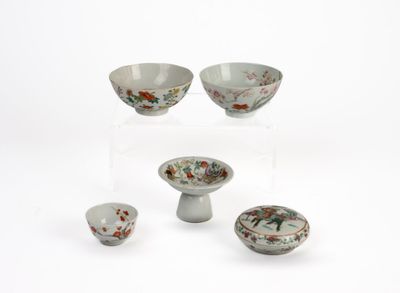 four bowls and a bowl on a stand on a white surface
